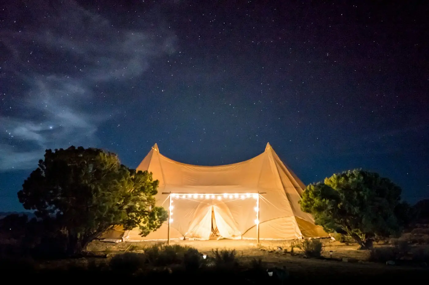 Verlichte belltent onder een sterrenhemel